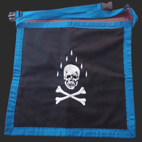 Parte trasera del mandil masónico de Compañero con cráneo, huesos cruzados y lágrimas. Simbolismo de muerte y reflexión en el Rito Escocés.